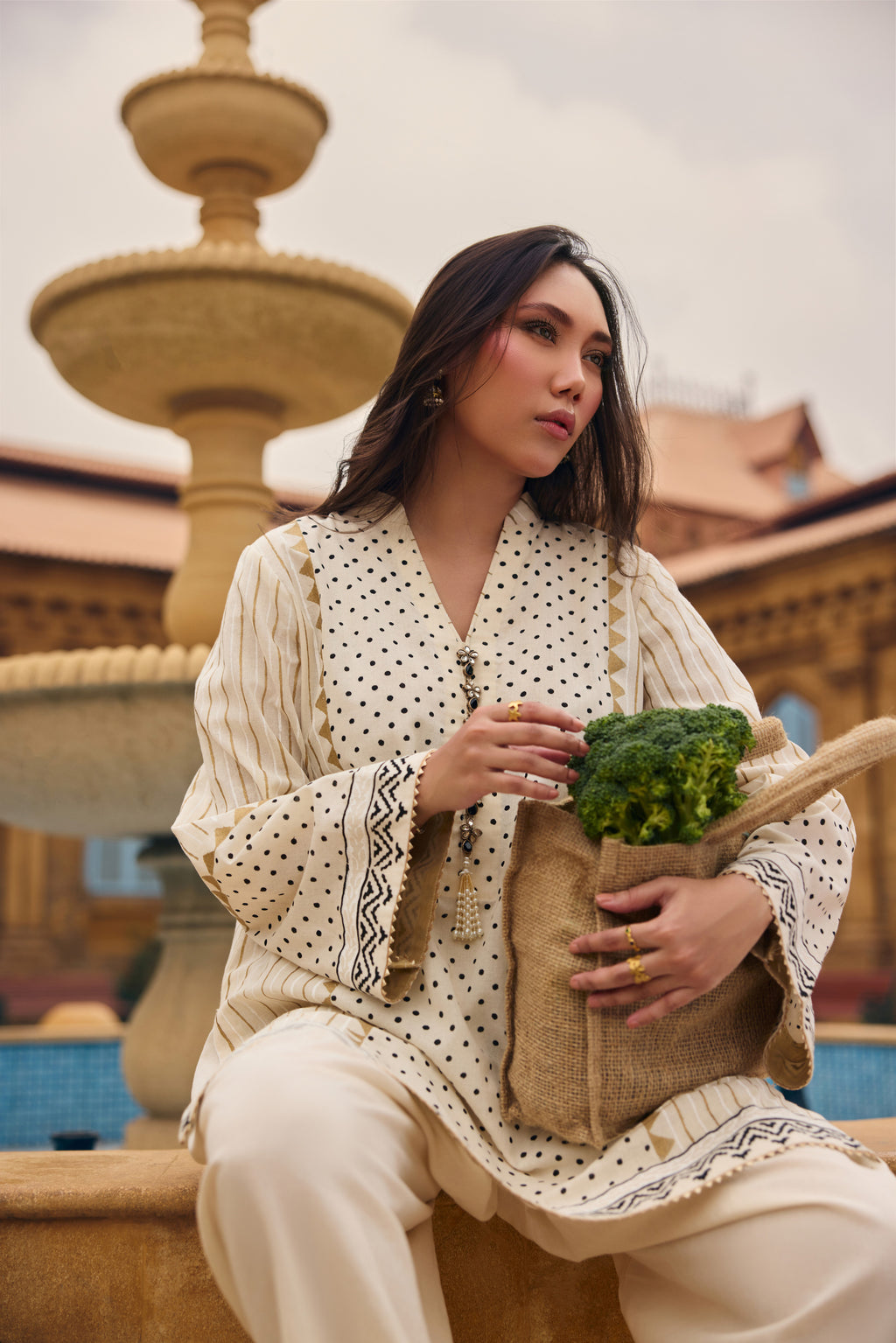 Coconut Sorbet kurta and dupatta, seated by a courtyard fountain