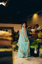 Back view of Mermaid Majesty in a fruit market, the gotta-trimmed block-printed dupatta over her shoulder