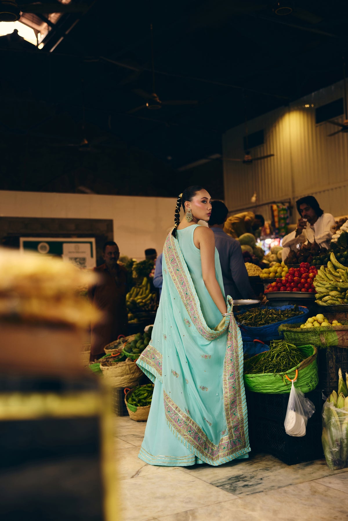 Back view of Mermaid Majesty in a fruit market, the gotta-trimmed block-printed dupatta over her shoulder